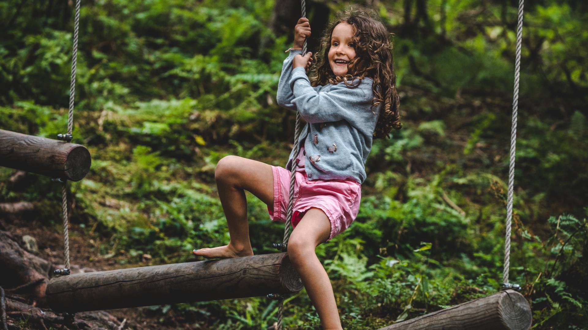 Kind spielt im Klettergarten im Wald