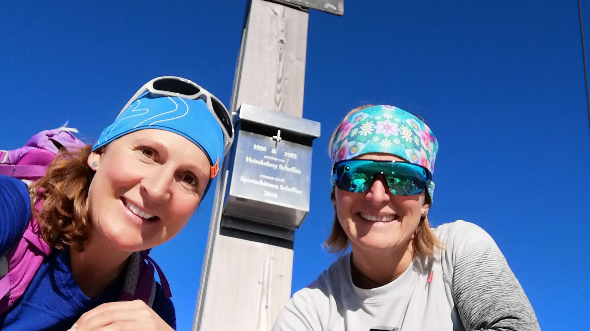 Zwei Wanderinnen beim Gipfelkreuz auf dem Wilden Kaiser