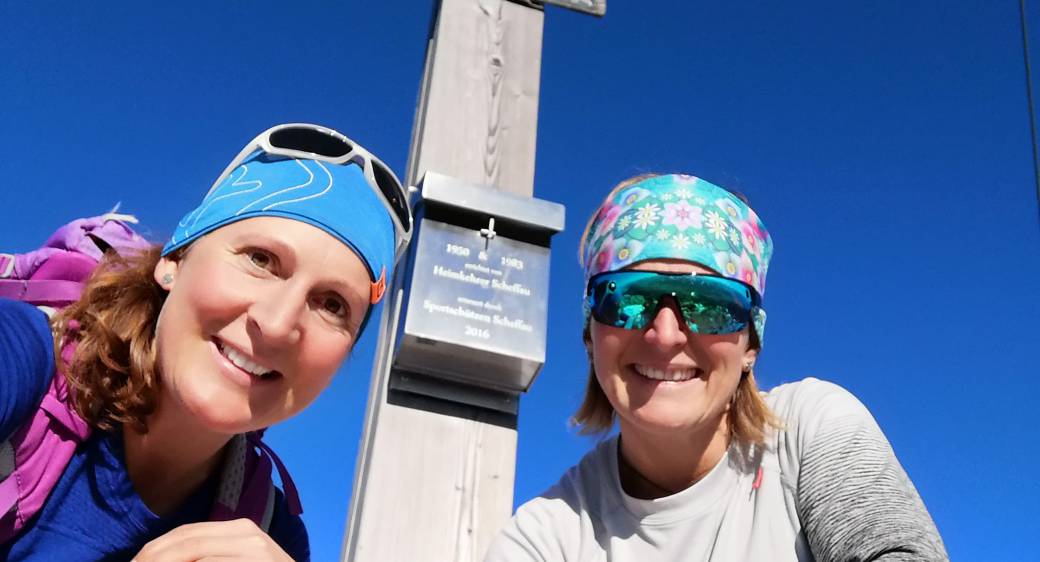 Zwei Wanderinnen beim Gipfelkreuz auf dem Wilden Kaiser