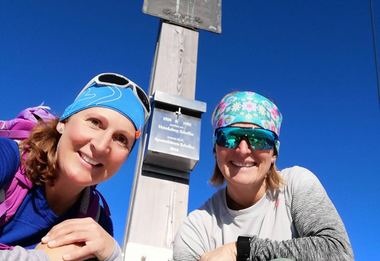 Zwei Wanderinnen beim Gipfelkreuz auf dem Wilden Kaiser