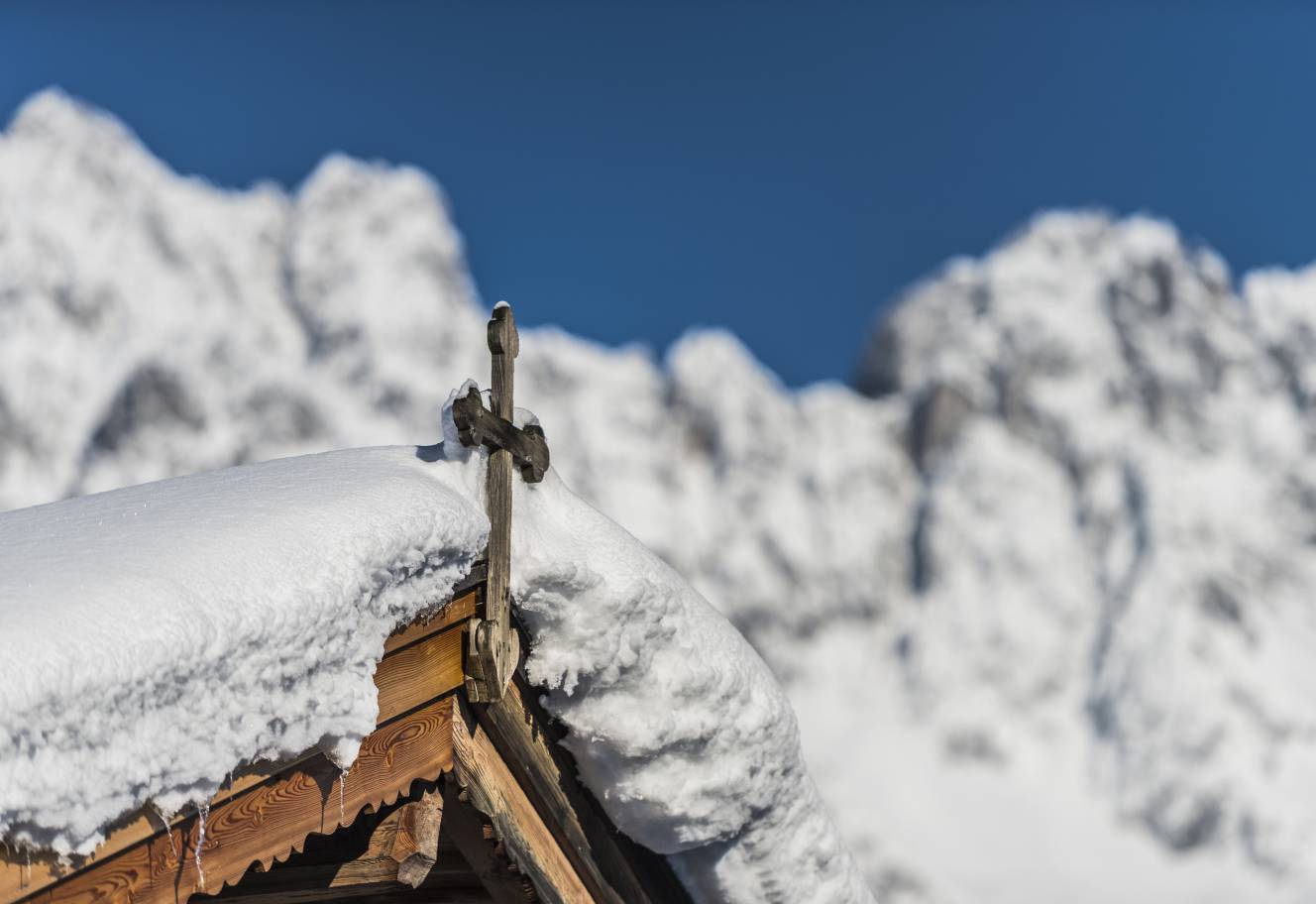 Kreuz auf einem verschneiten Dach