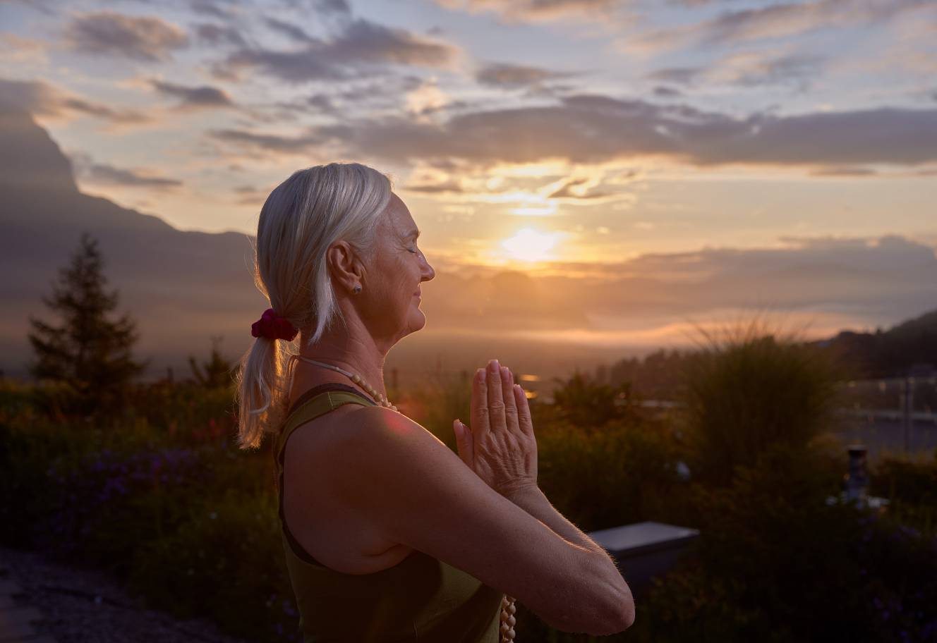 Frau macht Yoga beim Sonnenaufgang