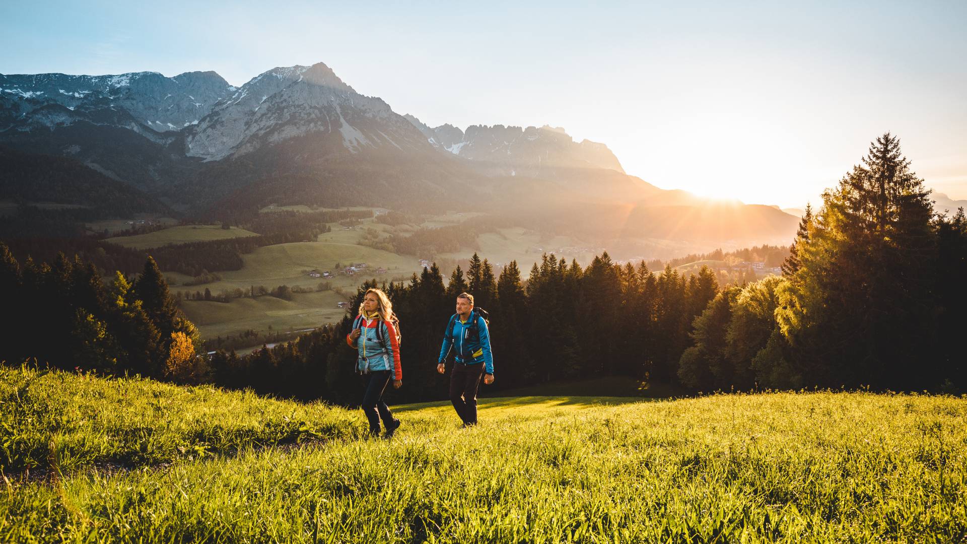 Wandern über Almwiesen bei Sonnenaufgang