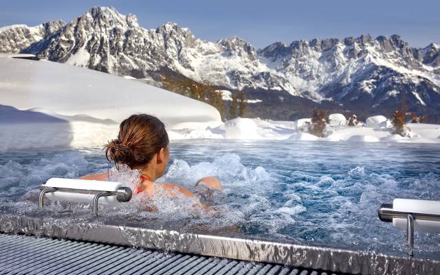 Frau im Whirlpool mit Panorama auf die Berge